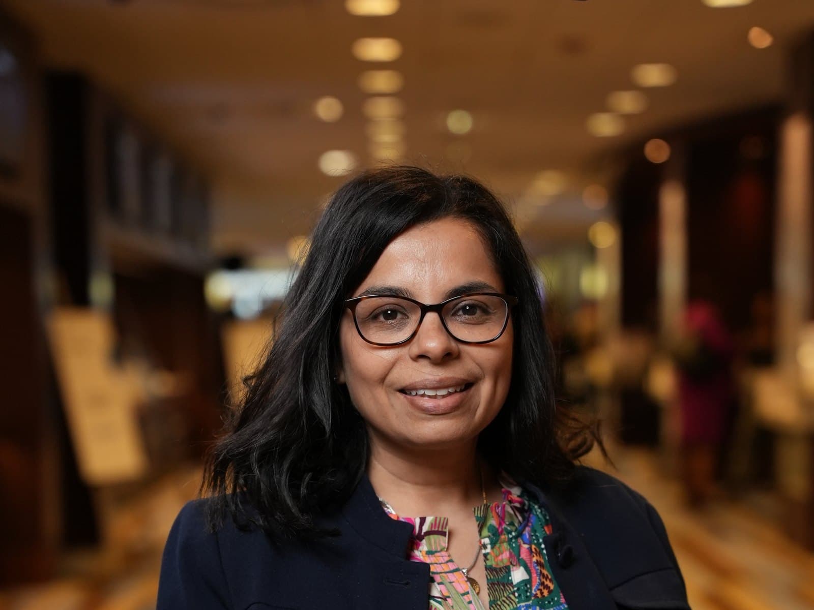 Dr. Mamata Majmundar in a navy blazer, photographed at a conference